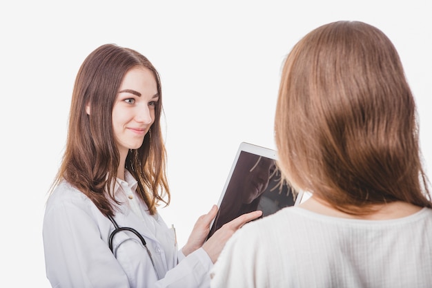 Pretty doctor showing tablet to patient