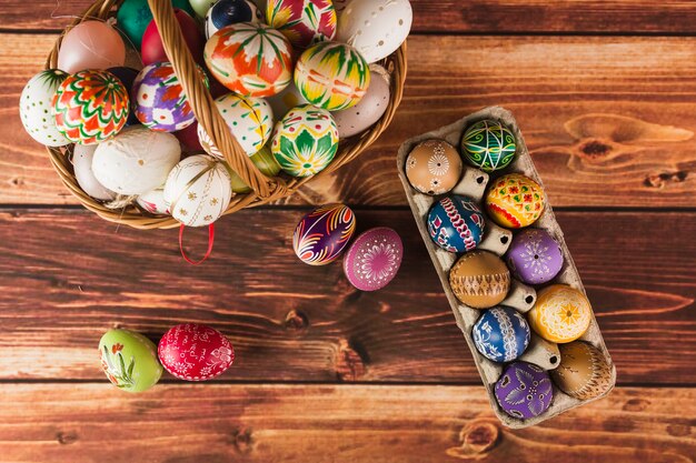 Pretty Easter eggs in basket and carton