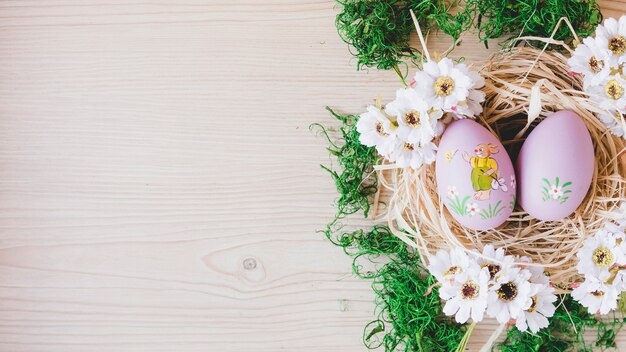 Pretty eggs and flowers in nest