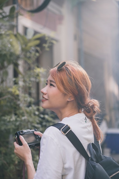 Free photo pretty ethnic woman traveling with camera