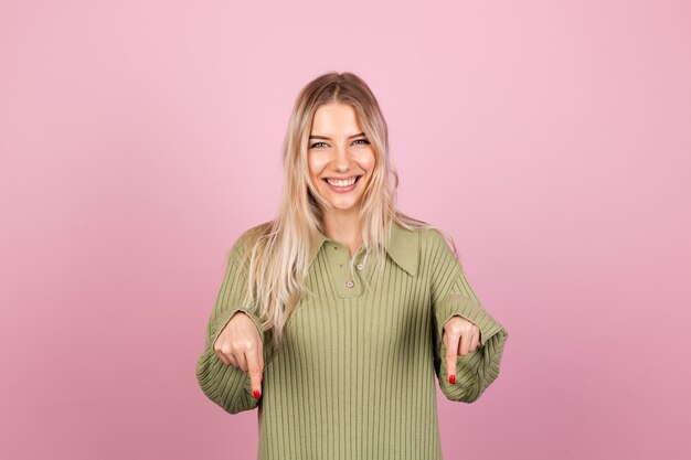 Pretty european woman in casual knitted sweater on pink wall