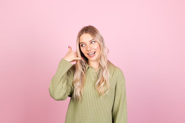 Довольно европейская женщина в повседневном свитере на розовой стене