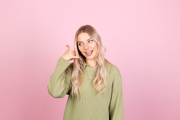 Pretty european woman in casual sweater on pink wall