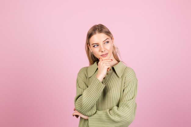 Pretty european woman in casual sweater on pink wall