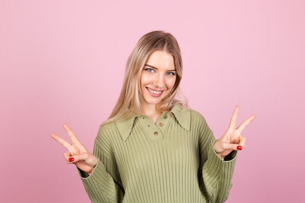 Donna abbastanza europea in maglione casual sulla parete rosa