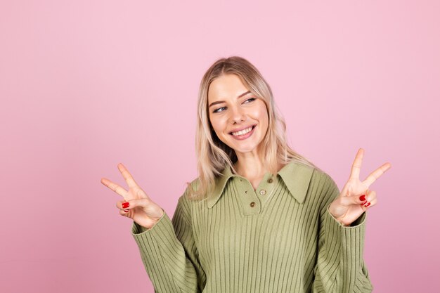 Pretty european woman in casual sweater on pink wall