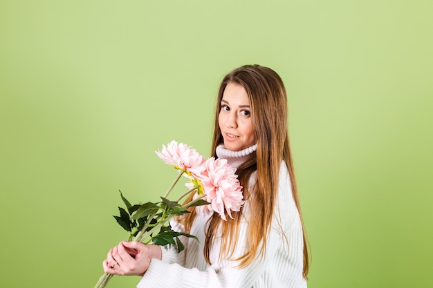 笑顔でピンクの花の花束を保持しているカジュアルな白いセーター孤立した、ロマンチックな外観のかなりヨーロッパの女性