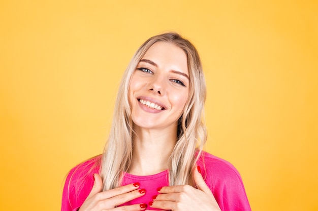 Бесплатное фото Довольно европейская женщина в розовой блузке на желтой стене