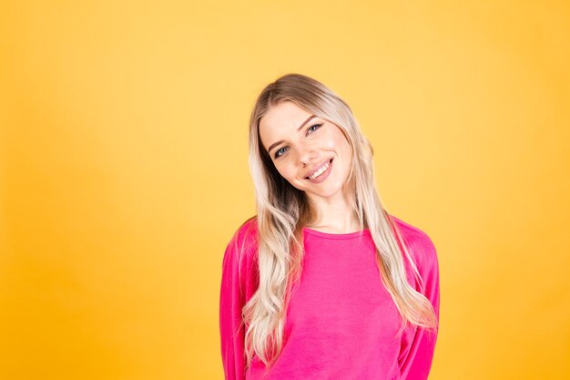 Pretty european woman in pink blouse on yellow wall