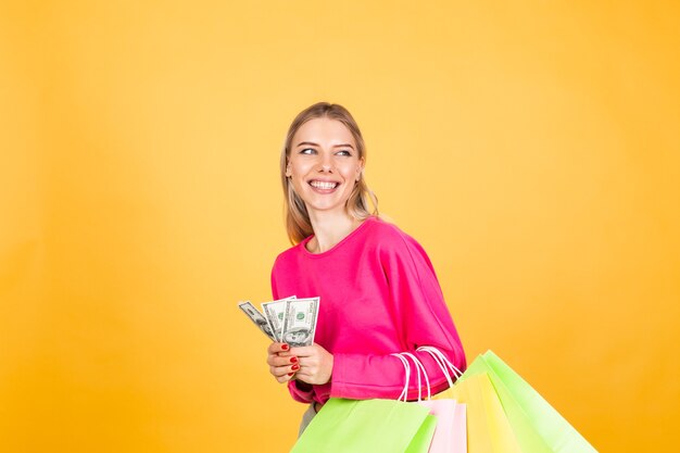 Pretty european woman in pink blouse on yellow wall