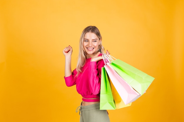 Pretty european woman in pink blouse on yellow wall