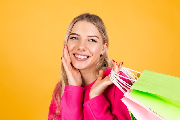 Pretty european woman in pink blouse on yellow wall