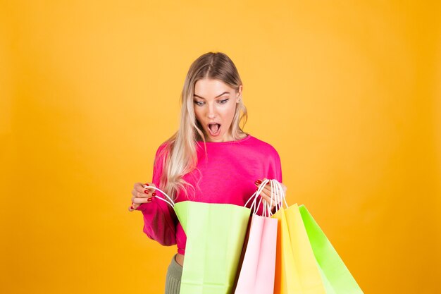 Pretty european woman in pink blouse on yellow wall