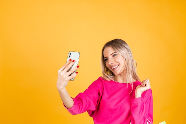 Pretty european woman in pink blouse on yellow wall