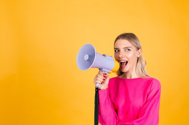 Pretty european woman in pink blouse on yellow wall