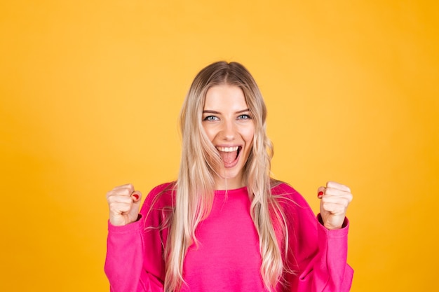 Free photo pretty european woman in pink blouse on yellow wall