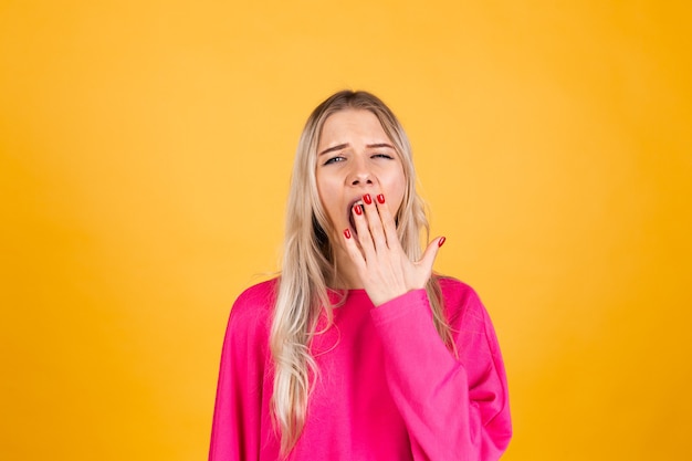 Pretty european woman in pink blouse on yellow wall