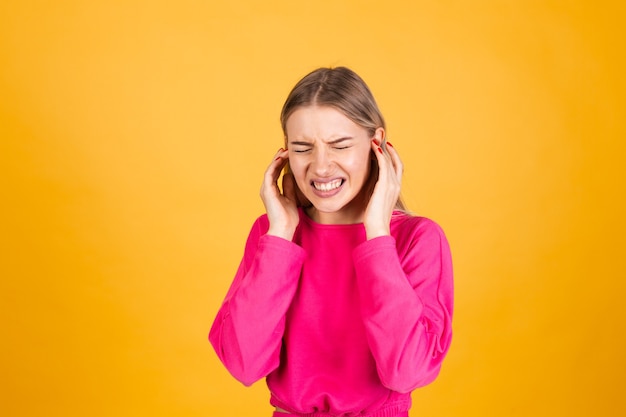 Free photo pretty european woman in pink blouse on yellow wall