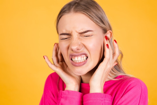 Free photo pretty european woman in pink blouse on yellow wall