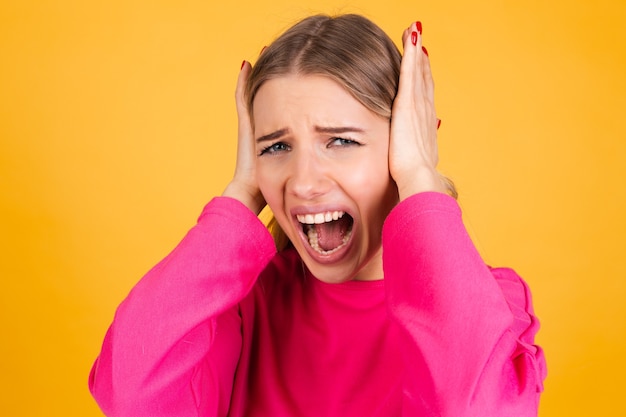 Free photo pretty european woman in pink blouse on yellow wall