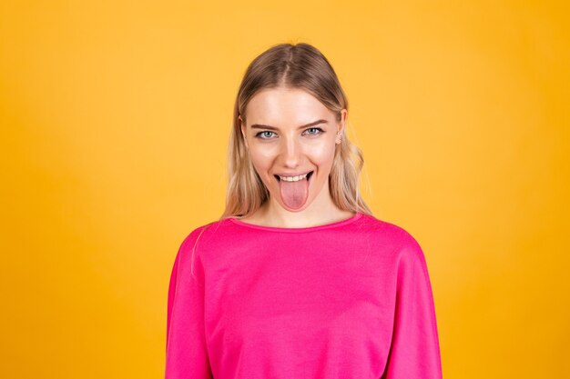 Pretty european woman in pink blouse on yellow wall
