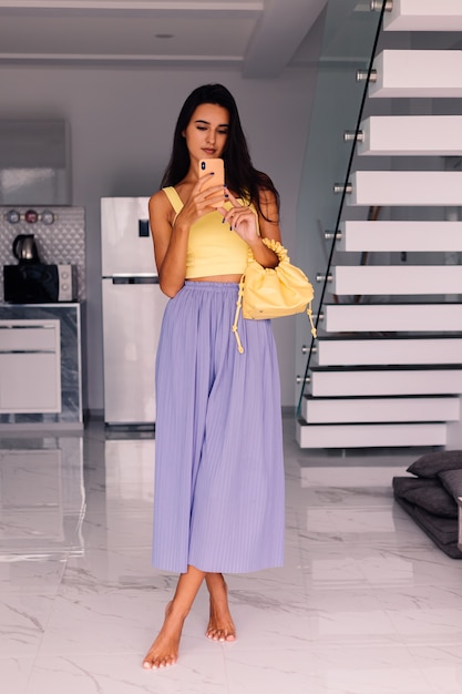 pretty fashion blogger woman wearing yellow top and purple pants