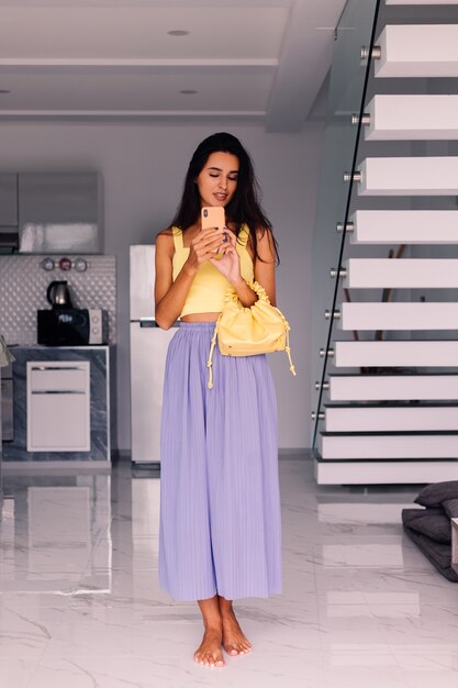 pretty fashion blogger woman wearing yellow top and purple pants