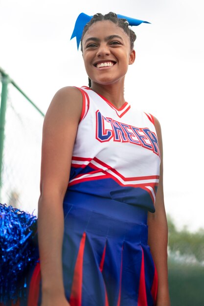 Pretty female cheerleader in cute uniform