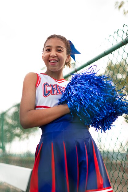 Pretty female cheerleader in cute uniform