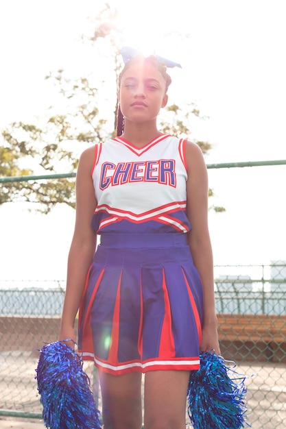 Pretty female cheerleader in cute uniform