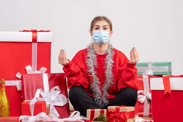 pretty female sitting around christmas presents on white