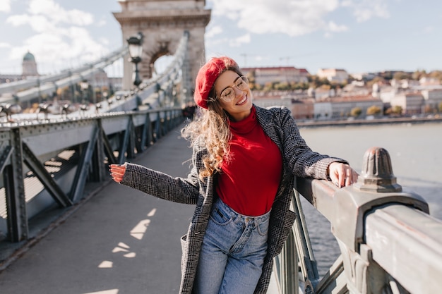 Pretty female tourist in casual outfit having fun in city of her dream