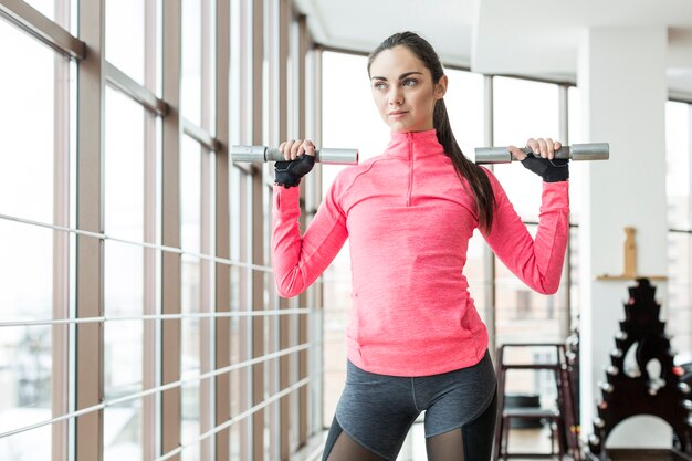 Pretty fit woman holding dumbbells