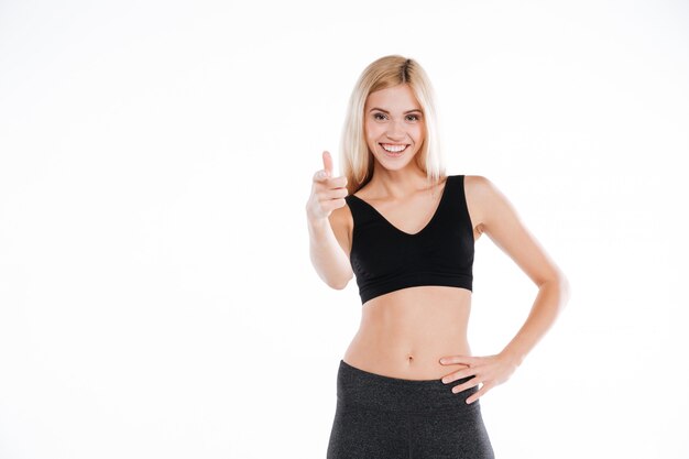 Pretty fitness lady pointing to camera