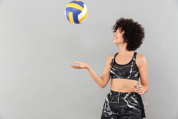 Pretty fitness woman playing with ball