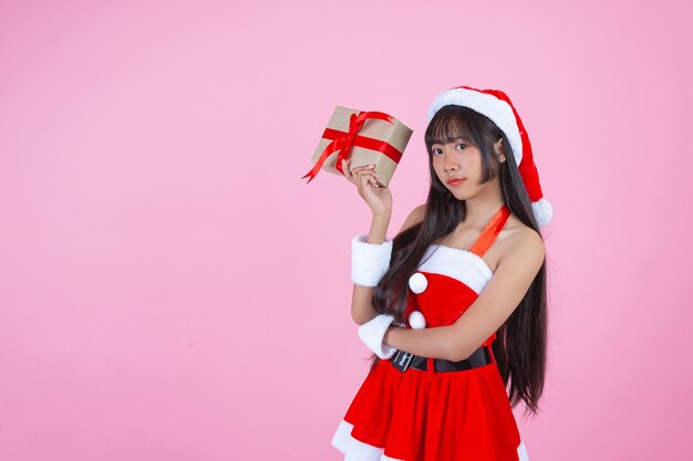 красивая девушка в рождественском костюме держит рождественский подарок
