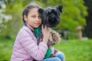 Free photo pretty girl embracing her dog outdoors