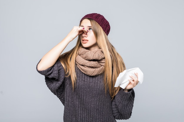 灰色のセーターを着たかわいい女の子が灰色に風邪インフルエンザの頭痛を起こした