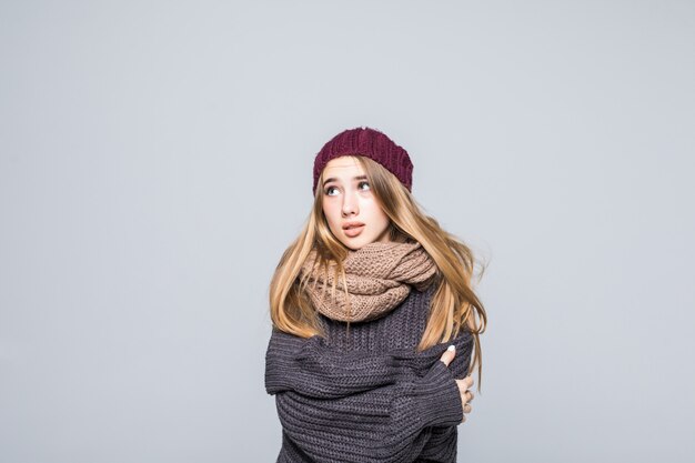 Foto gratuita bella ragazza in maglione grigio è freddo cercando di riscaldarsi sul grigio