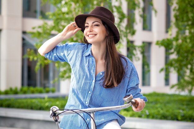 거리에서 자전거를 타는 모자에 예쁜 여자