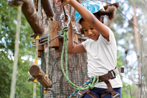 Foto gratuita bella ragazza che si diverte in un parco avventura