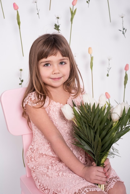 Pretty girl holding tulips medium shot