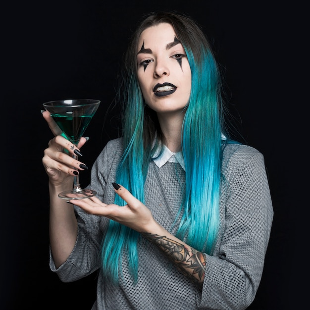 Pretty girl holding wineglass with green liquid