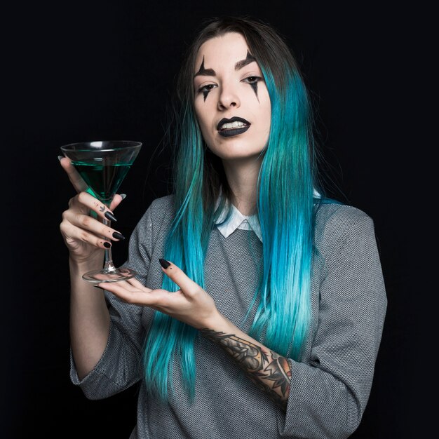 Pretty girl holding wineglass with green liquid