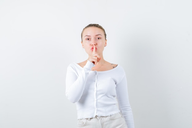 Free photo pretty girl is showing silent sign on white background