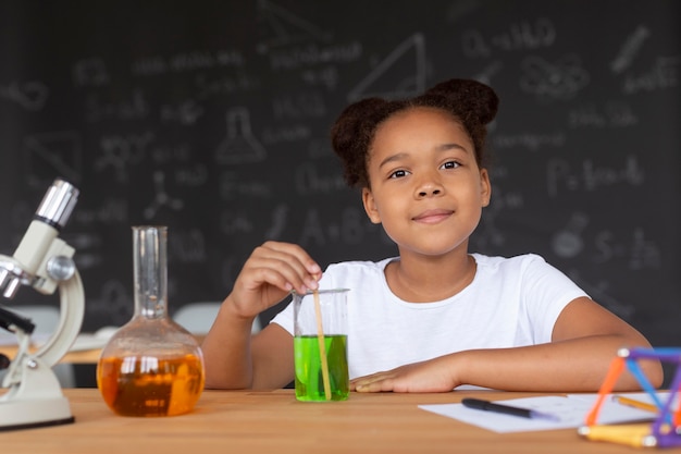 Pretty girl learning more about chemistry in class