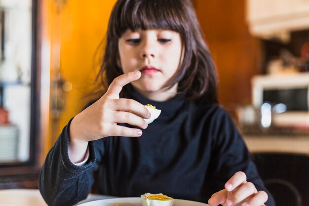 Pretty girl looking at half of egg