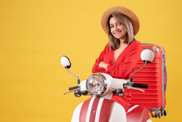pretty girl on moped with red suitcase crossing hands