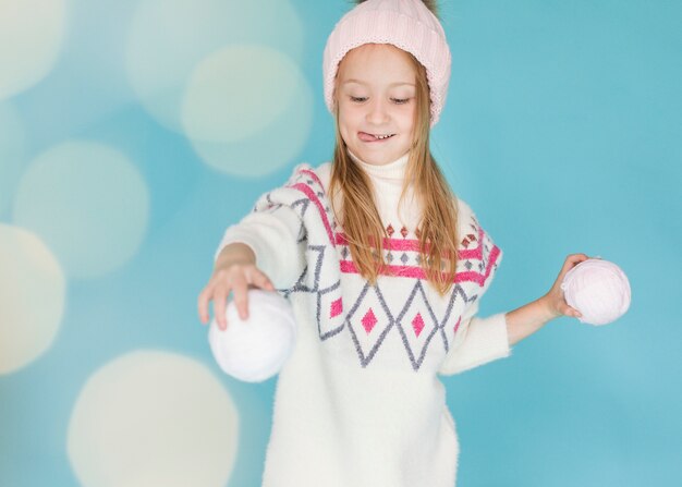 Pretty girl playing with snowballs