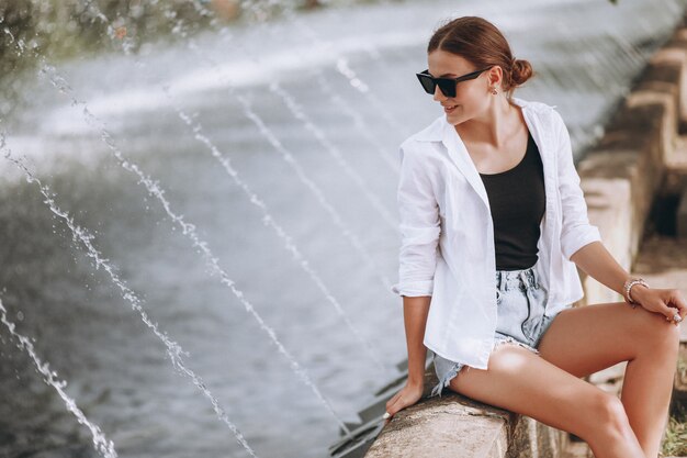 Pretty girl sitting by the fountains